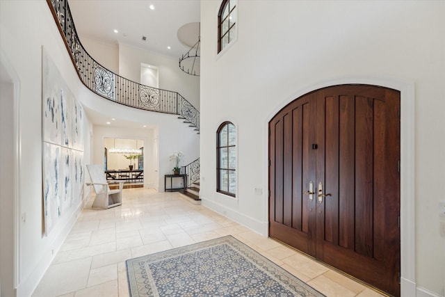 1039 Kirby Dr, Houston, TX 77019 - entrance foyer with stairway, light tile patterned floors, arched walkways, a high ceiling, and ornamental molding