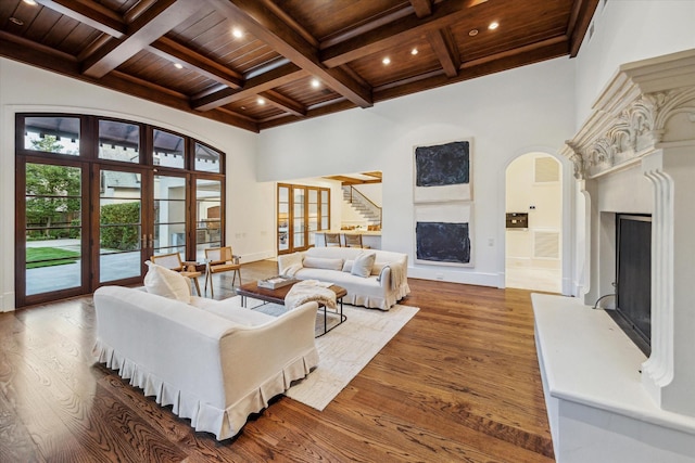 1039 Kirby Dr, Houston, TX 77019 - living room with a fireplace with raised hearth, a wooden ceiling with exposed beams, wood finished floors, coffered ceiling, and stairway