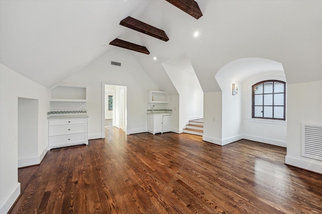 1039 Kirby Dr, Houston, TX 77019 - unfurnished living room featuring dark wood-style floors, built in features, stairs, and arched walkways