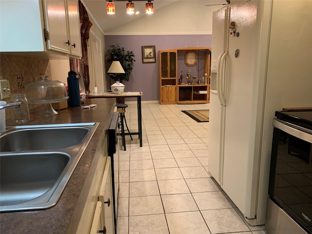 2709 8th Ave N, Texas City, TX 77590 - kitchen with stainless steel range with electric cooktop, backsplash, light tile patterned flooring, vaulted ceiling, and white refrigerator with ice dispenser