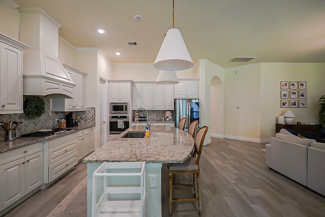 13114 Sierra National Dr, Humble, TX 77346 - kitchen with appliances with stainless steel finishes, wood finished floors, ornamental molding, decorative backsplash, and open floor plan