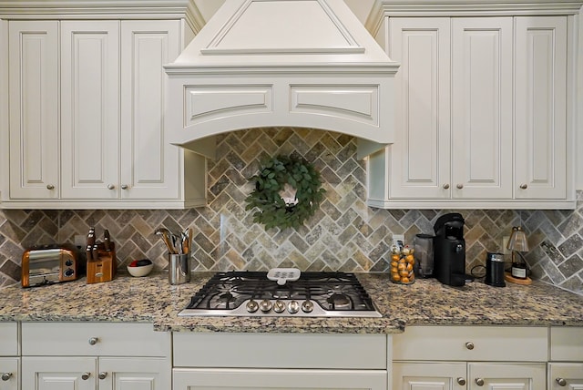 13114 Sierra National Dr, Humble, TX 77346 - kitchen with stainless steel gas stovetop, decorative backsplash, white cabinets, and stone countertops