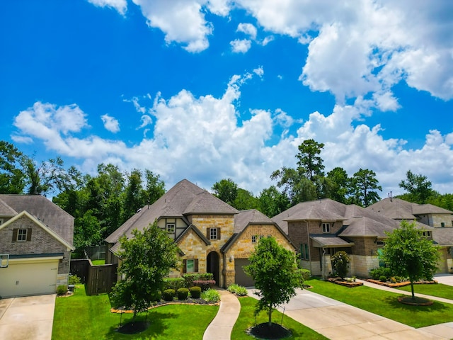 13114 Sierra National Dr, Humble, TX 77346 - french country home with driveway, stone siding, a front yard, and an attached garage