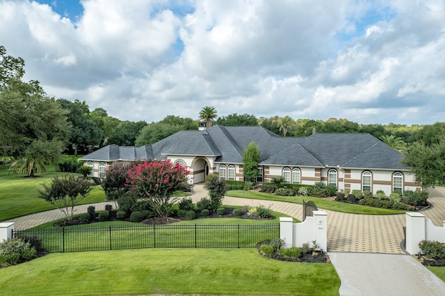 9603 Stonebridge Pl, Tomball, TX 77375 - french country home with curved driveway, a fenced front yard, stucco siding, and a gate