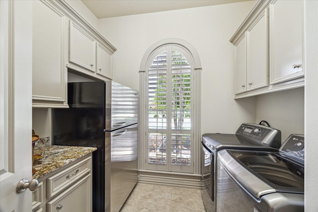 9603 Stonebridge Pl, Tomball, TX 77375 - laundry room featuring washer and dryer, cabinet space, and light tile patterned flooring