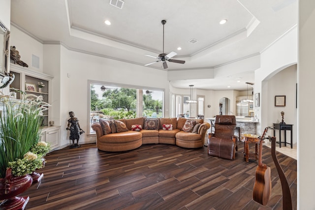 9603 Stonebridge Pl, Tomball, TX 77375 - living area with a tray ceiling, ceiling fan, arched walkways, ornamental molding, and dark wood-type flooring
