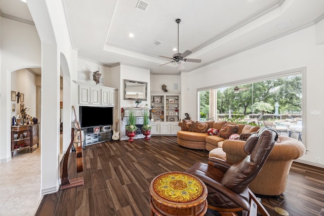 9603 Stonebridge Pl, Tomball, TX 77375 - living area featuring arched walkways, ornamental molding, a raised ceiling, a ceiling fan, and dark wood finished floors
