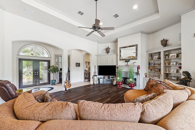 9603 Stonebridge Pl, Tomball, TX 77375 - living area featuring arched walkways, a raised ceiling, ceiling fan, french doors, and wood finished floors