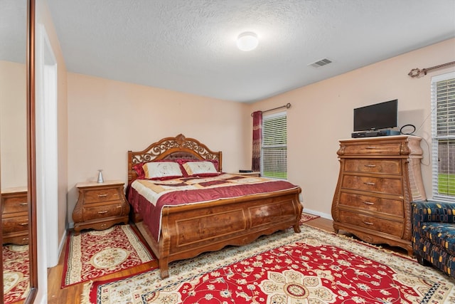 16307 Melody View Ct, Cypress, TX 77429 - bedroom with a textured ceiling and wood finished floors