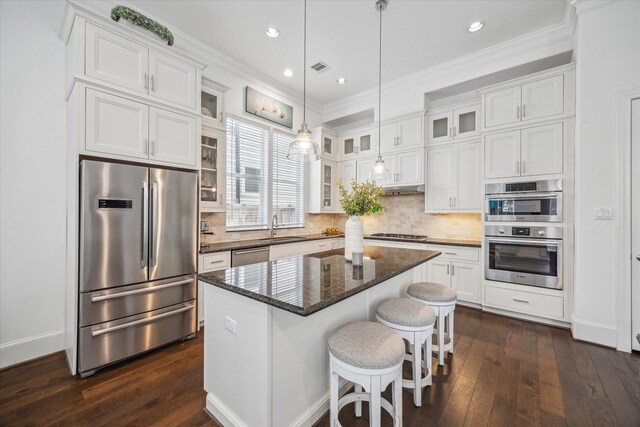 3410 Timbergrove Heights St, Houston, TX 77008 - kitchen with appliances with stainless steel finishes, white cabinets, a center island, dark wood finished floors, and ornamental molding