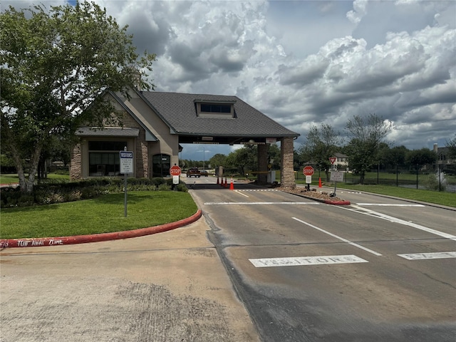 4714 Loggia Ln, Humble, TX 77396 - view of asphalt road featuring traffic signs, curbs, and a gated entry