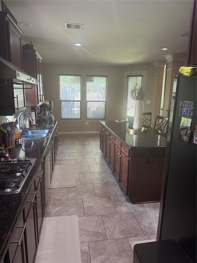 4714 Loggia Ln, Humble, TX 77396 - kitchen with appliances with stainless steel finishes, dark stone counters, a kitchen island, dark brown cabinets, and recessed lighting