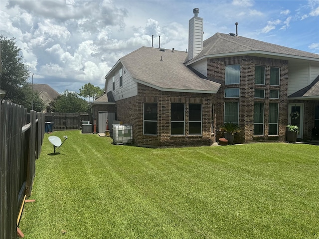 4714 Loggia Ln, Humble, TX 77396 - rear view of property featuring a fenced backyard, a shingled roof, brick siding, and a chimney