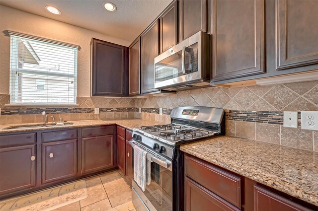 3306 Coopers Ridge Way, Houston, TX 77084 - kitchen with stainless steel appliances, tasteful backsplash, light stone counters, recessed lighting, and light tile patterned flooring