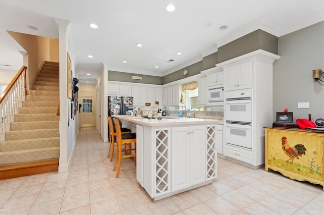 15 S Lakemist Harbour Pl, The Woodlands, TX 77381 - kitchen featuring white appliances, white cabinetry, ornamental molding, light countertops, and recessed lighting