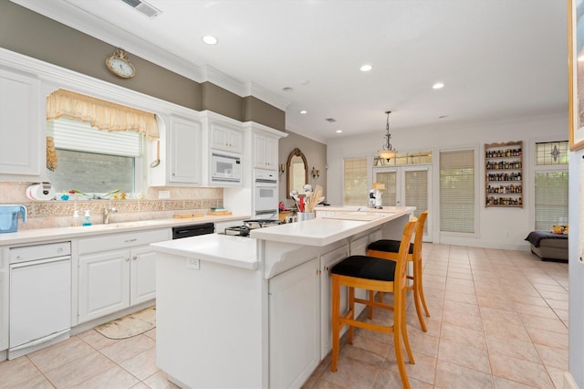 15 S Lakemist Harbour Pl, The Woodlands, TX 77381 - kitchen with ornamental molding, white appliances, an island with sink, recessed lighting, and white cabinetry