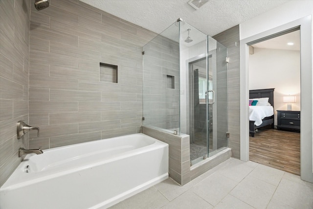 8218 Waynemer Way, Houston, TX 77040 - ensuite bathroom featuring a shower stall, a bath, tile patterned flooring, and a textured ceiling