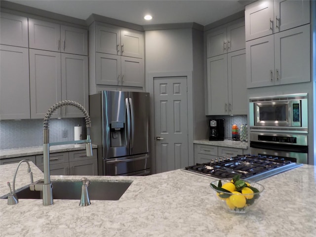 12636 Briar Patch Rd, Houston, TX 77077 - kitchen with stainless steel appliances, gray cabinets, backsplash, recessed lighting, and light stone countertops
