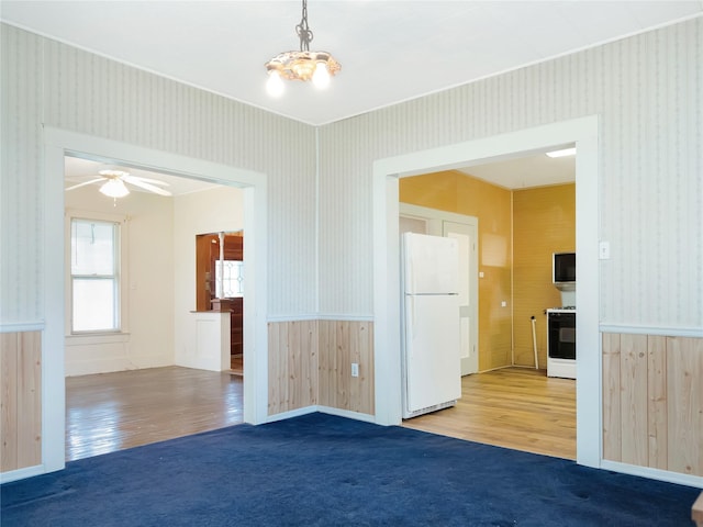 1233 Eagle Lake Rd, Sealy, TX 77474 - carpeted spare room with wallpapered walls, a wainscoted wall, wood finished floors, a ceiling fan, and crown molding