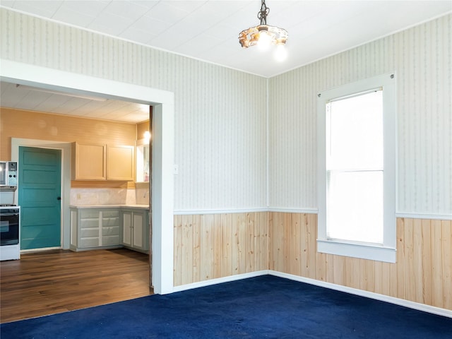 1233 Eagle Lake Rd, Sealy, TX 77474 - empty room with wainscoting, dark wood-type flooring, wood walls, wallpapered walls, and ornamental molding
