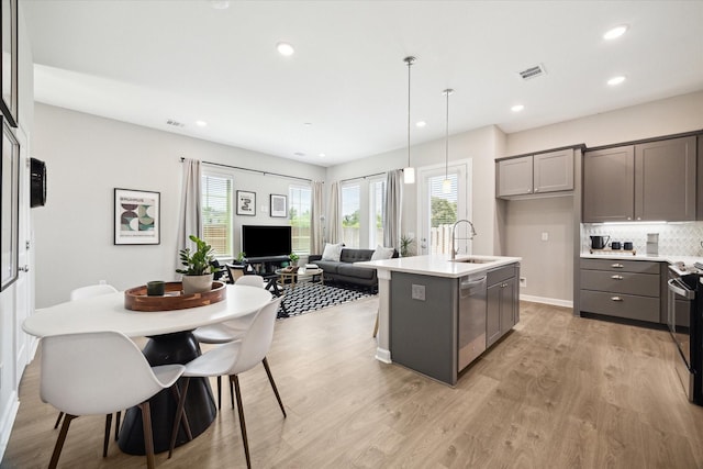 6024 T C Jester Blvd, Houston, TX 77091 - kitchen featuring gray cabinets, stainless steel appliances, a center island with sink, light wood-type flooring, and recessed lighting