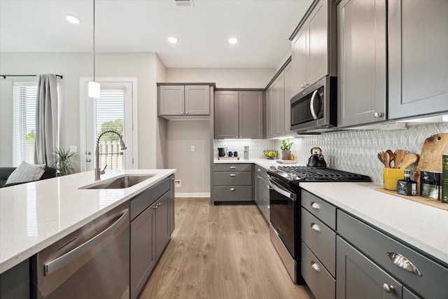 6024 T C Jester Blvd, Houston, TX 77091 - kitchen with stainless steel appliances, light wood-style floors, gray cabinets, tasteful backsplash, and recessed lighting