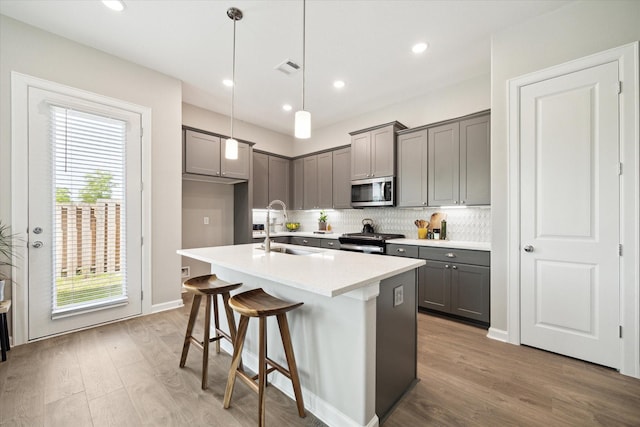 6024 T C Jester Blvd, Houston, TX 77091 - kitchen featuring gray cabinets, stainless steel microwave, tasteful backsplash, black stove, and wood finished floors