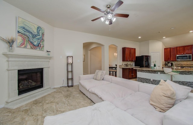 15218 Zenith Glen Ln, Cypress, TX 77429 - living area with arched walkways, a ceiling fan, a glass covered fireplace, and recessed lighting