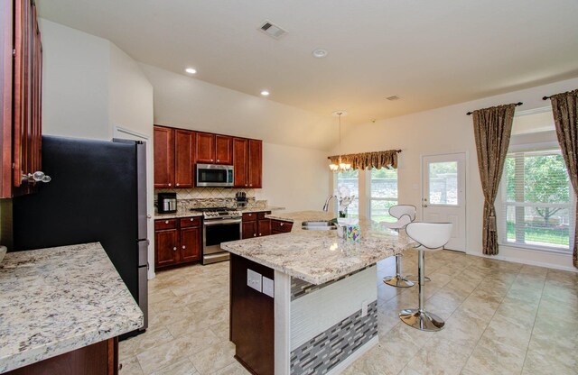 15218 Zenith Glen Ln, Cypress, TX 77429 - kitchen with stainless steel appliances, healthy amount of natural light, backsplash, a kitchen breakfast bar, and vaulted ceiling