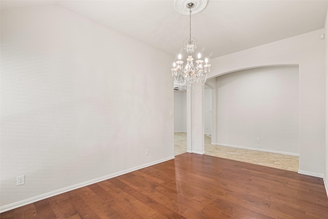15218 Zenith Glen Ln, Cypress, TX 77429 - spare room featuring hardwood / wood-style flooring, arched walkways, and a chandelier