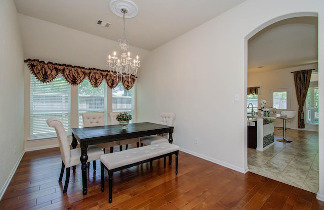 15218 Zenith Glen Ln, Cypress, TX 77429 - dining room featuring arched walkways, a chandelier, wood finished floors, and plenty of natural light