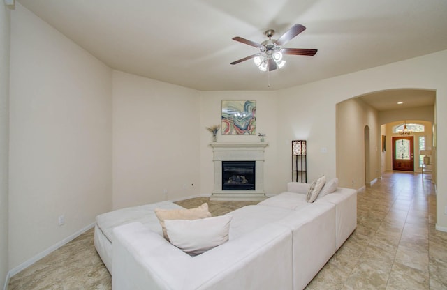 15218 Zenith Glen Ln, Cypress, TX 77429 - living room with arched walkways, a glass covered fireplace, and ceiling fan