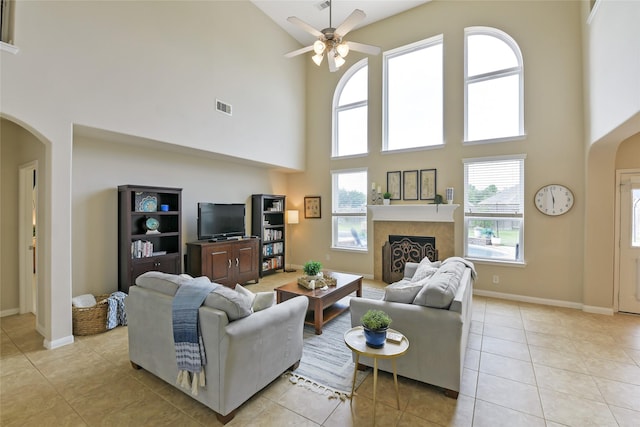 19538 Salt Grass Meadow Dr, Cypress, TX 77433 - living area with high vaulted ceiling, arched walkways, a ceiling fan, light tile patterned floors, and a fireplace
