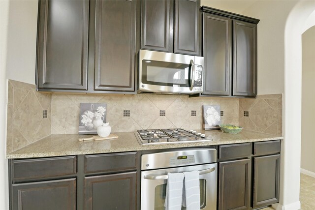 19538 Salt Grass Meadow Dr, Cypress, TX 77433 - kitchen with appliances with stainless steel finishes, arched walkways, and tasteful backsplash