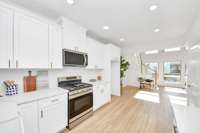 300 Narcissus Rd, Clear Lake Shores, TX 77565 - kitchen featuring stainless steel appliances, white cabinetry, recessed lighting, light wood-style flooring, and decorative backsplash