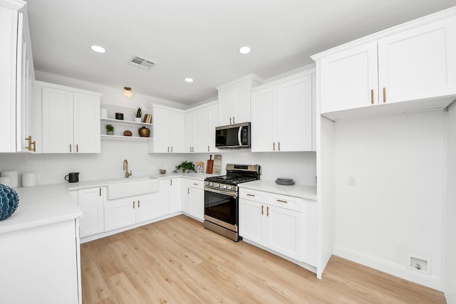300 Narcissus Rd, Clear Lake Shores, TX 77565 - kitchen with appliances with stainless steel finishes, open shelves, light wood-type flooring, recessed lighting, and white cabinets