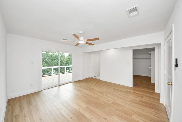 300 Narcissus Rd, Clear Lake Shores, TX 77565 - unfurnished bedroom featuring access to exterior, light wood finished floors, a ceiling fan, and a walk in closet
