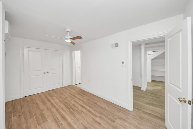 300 Narcissus Rd, Clear Lake Shores, TX 77565 - unfurnished bedroom with light wood-style flooring, a closet, ceiling fan, and a wall unit AC