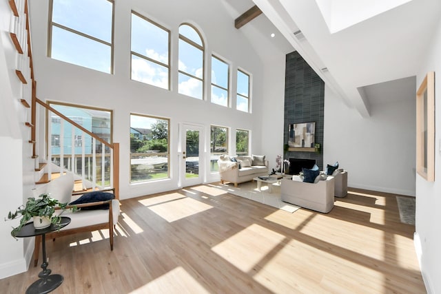300 Narcissus Rd, Clear Lake Shores, TX 77565 - living area with high vaulted ceiling, wood finished floors, stairway, a large fireplace, and beam ceiling