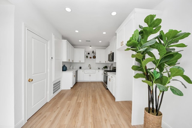 300 Narcissus Rd, Clear Lake Shores, TX 77565 - kitchen featuring stainless steel range with gas stovetop, light wood-type flooring, open shelves, recessed lighting, and white cabinetry