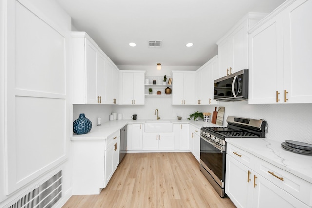 300 Narcissus Rd, Clear Lake Shores, TX 77565 - kitchen featuring stainless steel appliances, open shelves, light wood-style flooring, recessed lighting, and white cabinetry