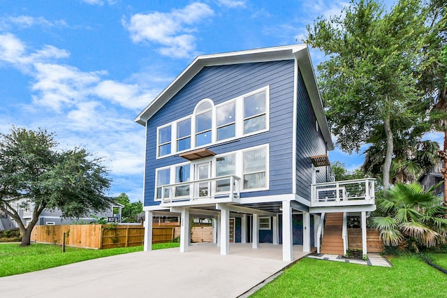 300 Narcissus Rd, Clear Lake Shores, TX 77565 - rear view of property with a carport, concrete driveway, and a balcony