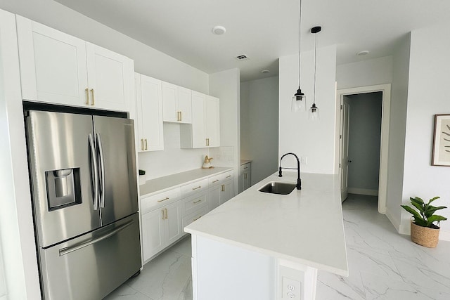 8128 Penrod St, Houston, TX 77028 - kitchen with stainless steel refrigerator with ice dispenser, light marble finish floors, white cabinets, and hanging light fixtures