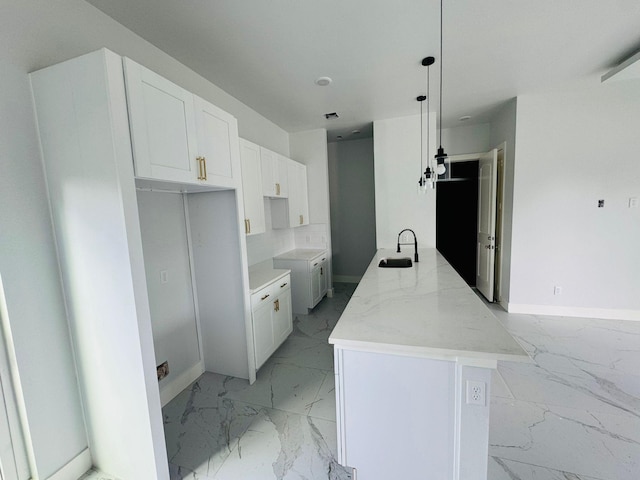 8128 Penrod St, Houston, TX 77028 - kitchen featuring light marble finish floors, white cabinetry, light stone countertops, and decorative light fixtures