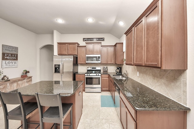 18614 Magnolia Dell Dr, Cypress, TX 77433 - kitchen with appliances with stainless steel finishes, tasteful backsplash, a kitchen island, dark stone countertops, and recessed lighting