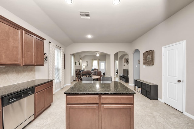18614 Magnolia Dell Dr, Cypress, TX 77433 - kitchen featuring stainless steel dishwasher, arched walkways, open floor plan, dark stone counters, and light tile patterned floors
