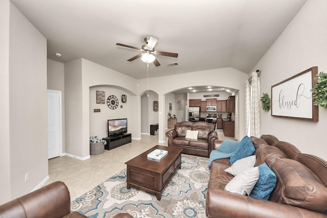 18614 Magnolia Dell Dr, Cypress, TX 77433 - living area with arched walkways, a ceiling fan, vaulted ceiling, and light tile patterned floors