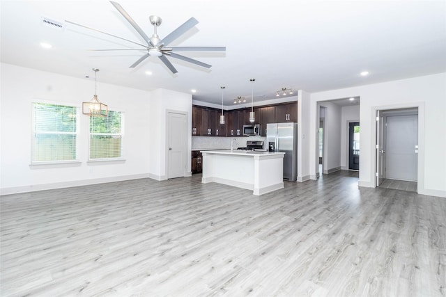 10513 Chesterfield Dr, Houston, TX 77051 - unfurnished living room featuring light wood-type flooring, recessed lighting, a ceiling fan, and a chandelier
