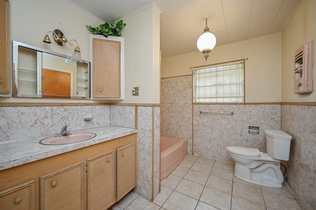 702 Mcdaniel St, Houston, TX 77022 - full bath with ornamental molding, tile walls, vanity, tile patterned flooring, and wainscoting