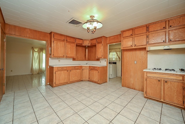 702 Mcdaniel St, Houston, TX 77022 - kitchen with light countertops, washer / dryer, white gas stovetop, plenty of natural light, and wooden walls